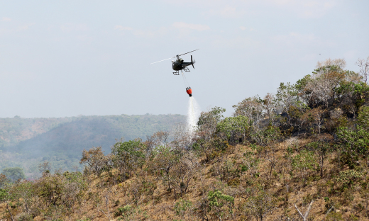 Helicóptero do IBAMA lança água para combater foco de incêndio na região de Taquarussu Grande, zona rural de Palmas