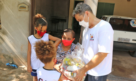Professor de educação física e diretor da Agab, Glauco Flores, entregando os alimentos para a família da cadeirante e mãe de alunas, Jorciene Mendes Martins