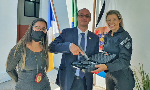 Secretário Cristiano Sampaio (C) e delegada regional de Araguaína, Ana Maria Varjal, entregam arma para policial civil de Araguaína