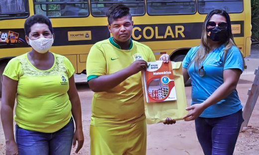 Materiais de estudos sendo entregues para estudante do 6º ano em rota do transporte escolar